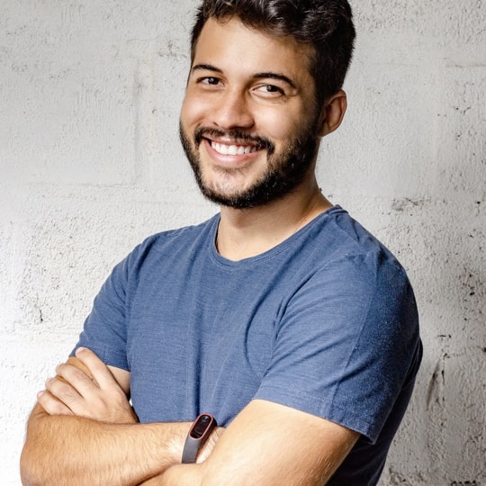 Photo of a young man smiling and folding his hands